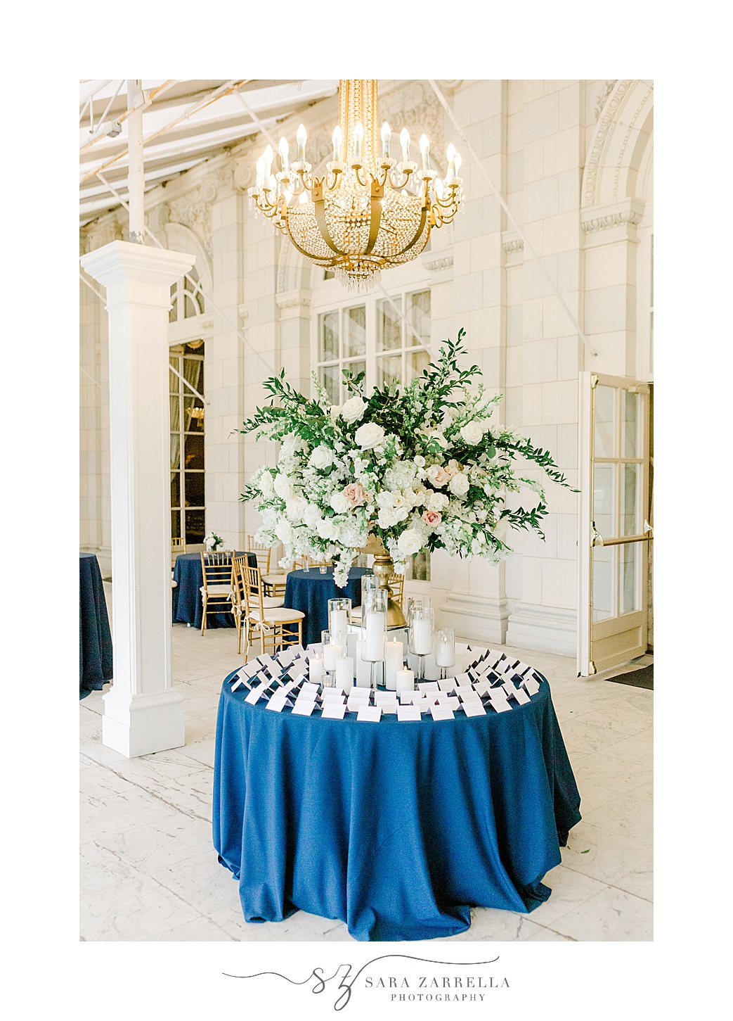 welcome table with escort cards on blue table cloth 