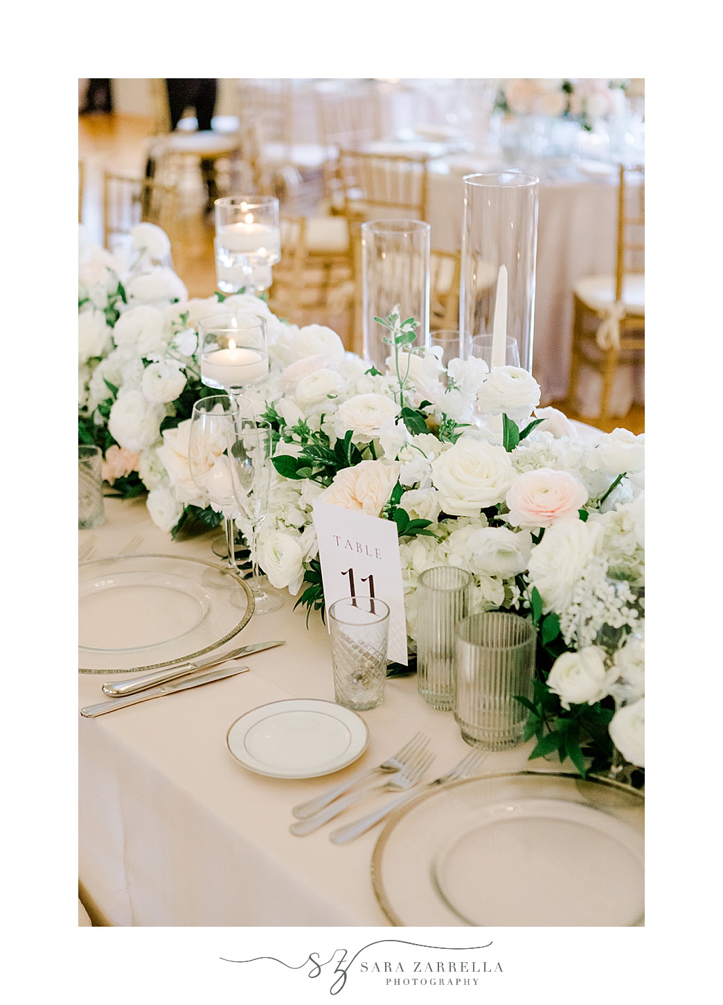 wedding reception with white and pink flowers with gold rimmed plates 