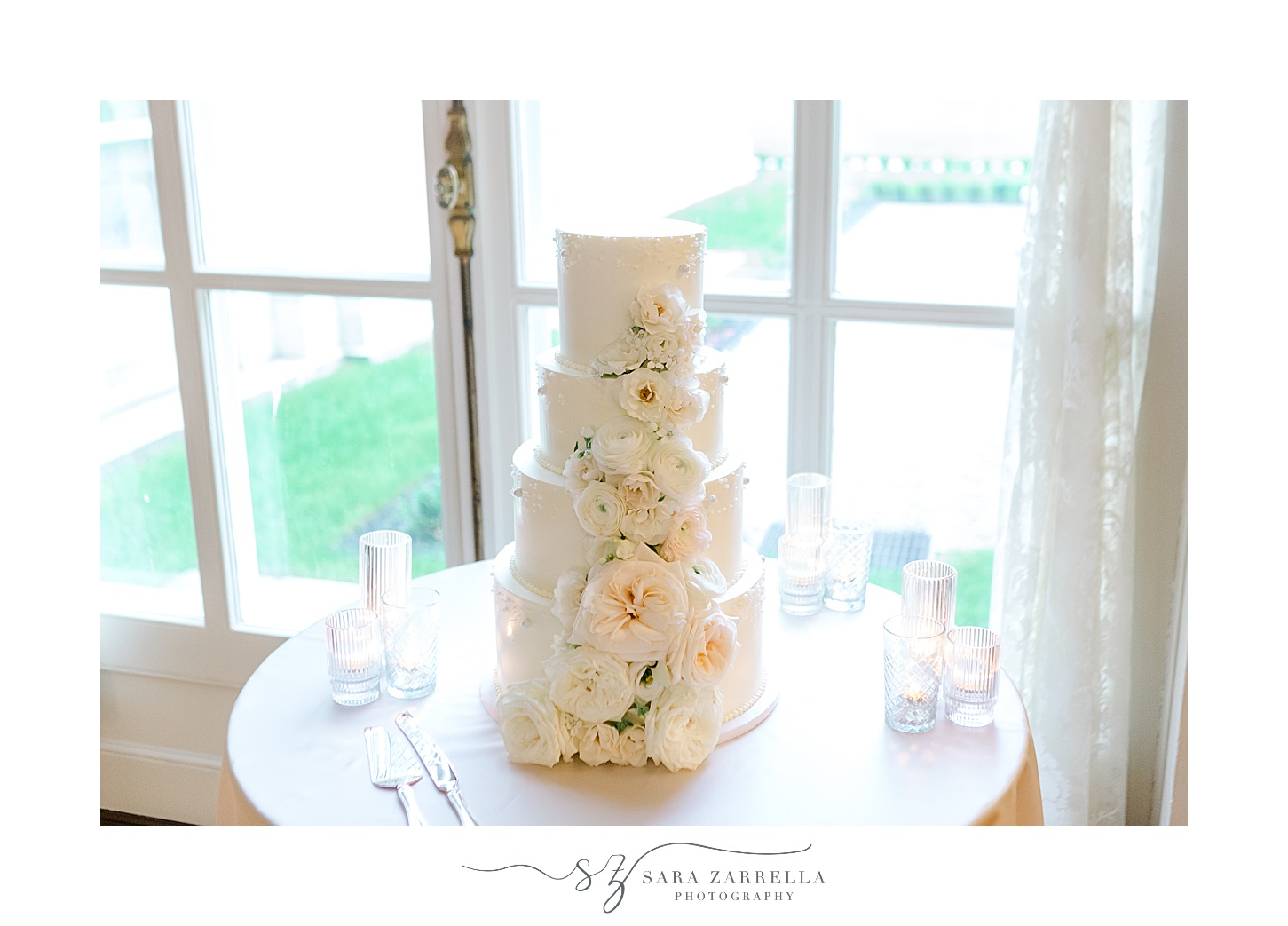 tiered wedding cake with floral accents at Rosecliff Mansion