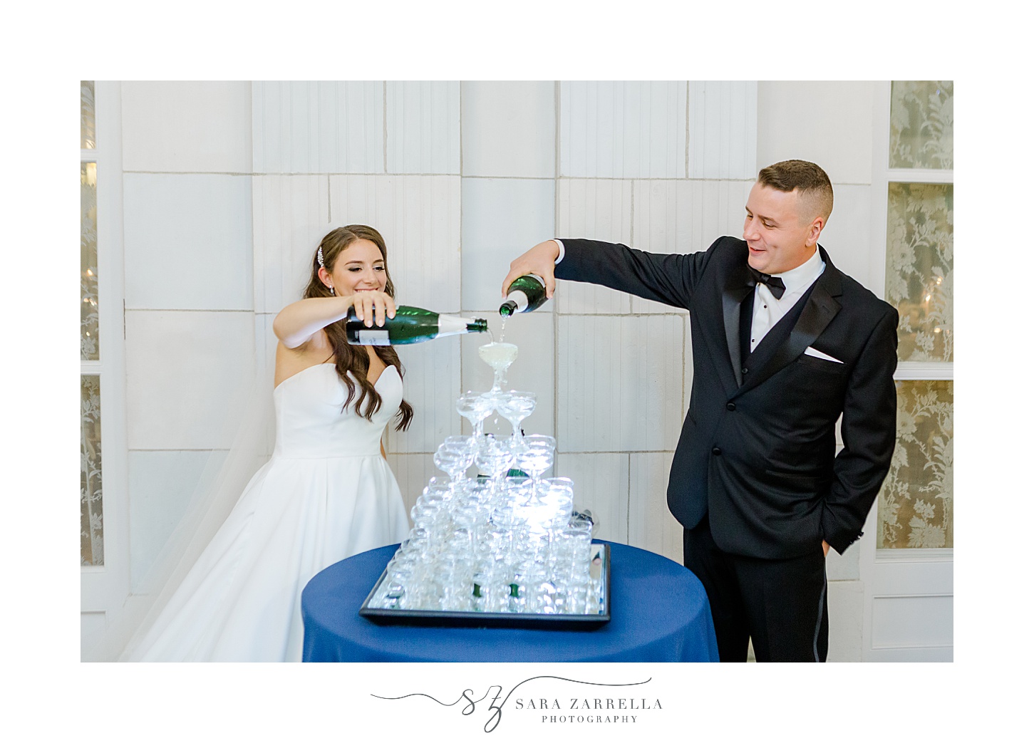 bride and groom pour champagne down tower of glasses at Newport RI wedding reception