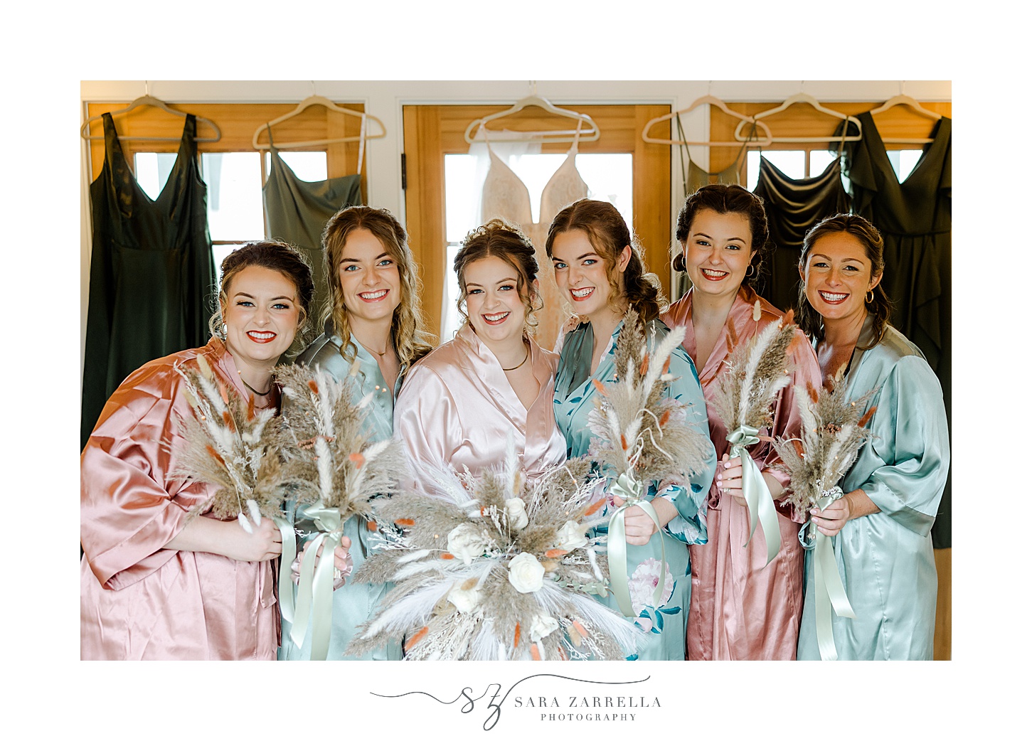 bride poses with bridesmaids in satin robes