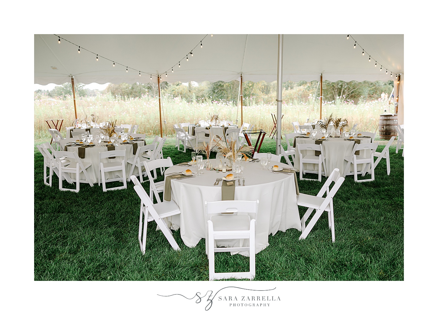 tented reception on lawn of Rhode Island private residence with white chairs and lighting