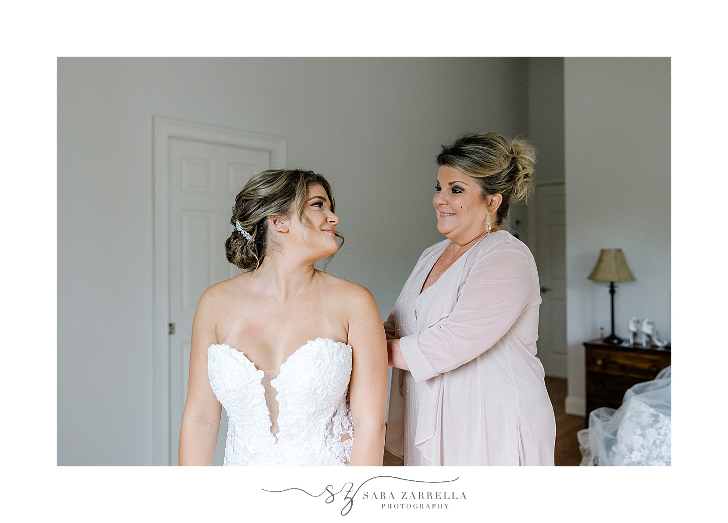 bride looks back over shoulder at mother during Westerly RI wedding prep