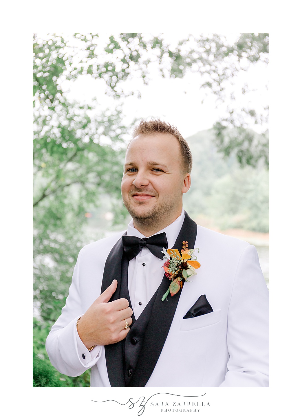 groom holds black lapel on white suit before Westerly RI wedding day