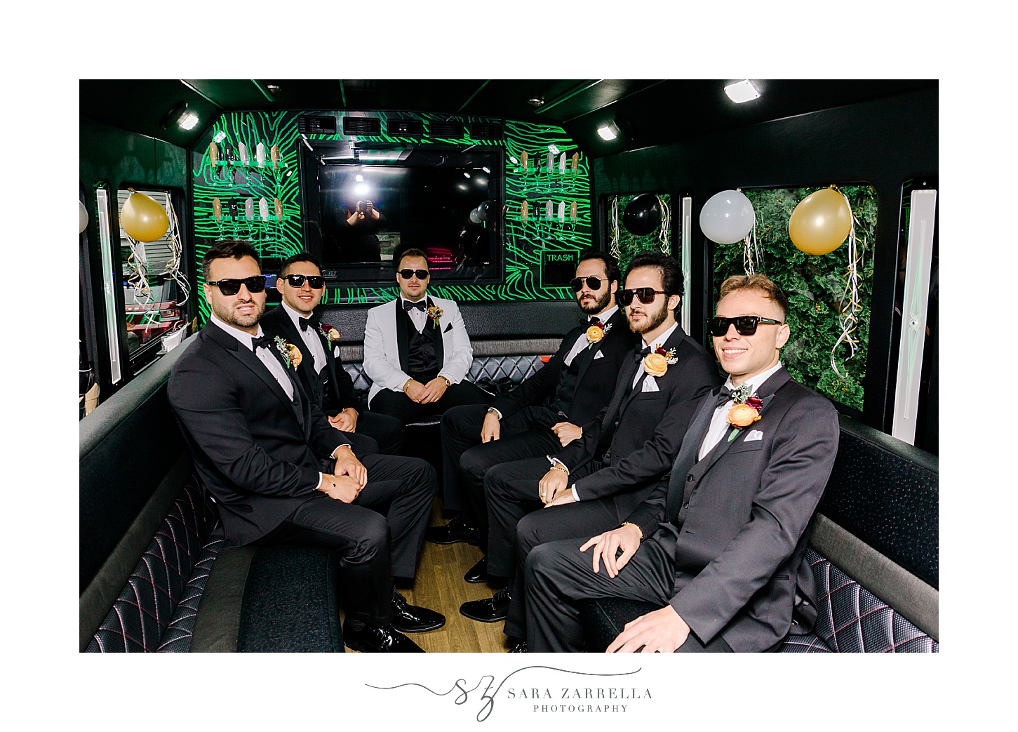 groom sits with groomsmen inside limo on wedding day