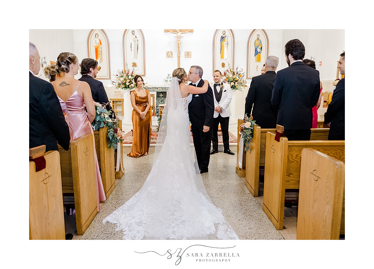 bride hugs father during wedding ceremony at St Pius Church in Westerly RI