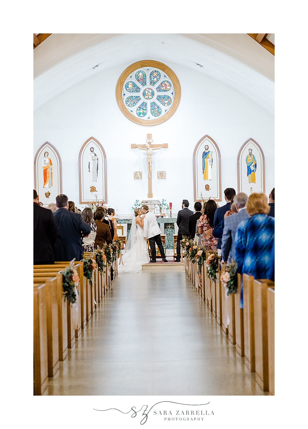 bride and groom pose at end of the alter during wedding ceremony at St Pius Church in Westerly RI