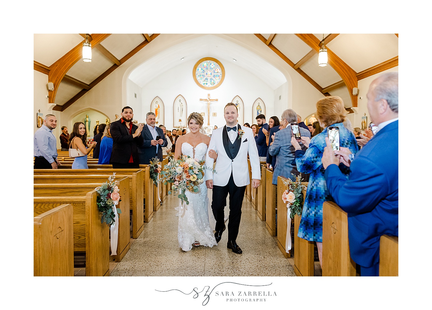 bride and groom walk up aisle during wedding ceremony at St Pius Church in Westerly RI