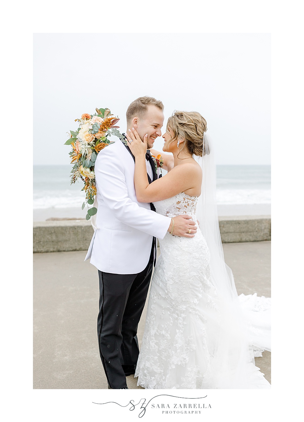 bride and groom lean to kiss along beachfront in Westerly RI