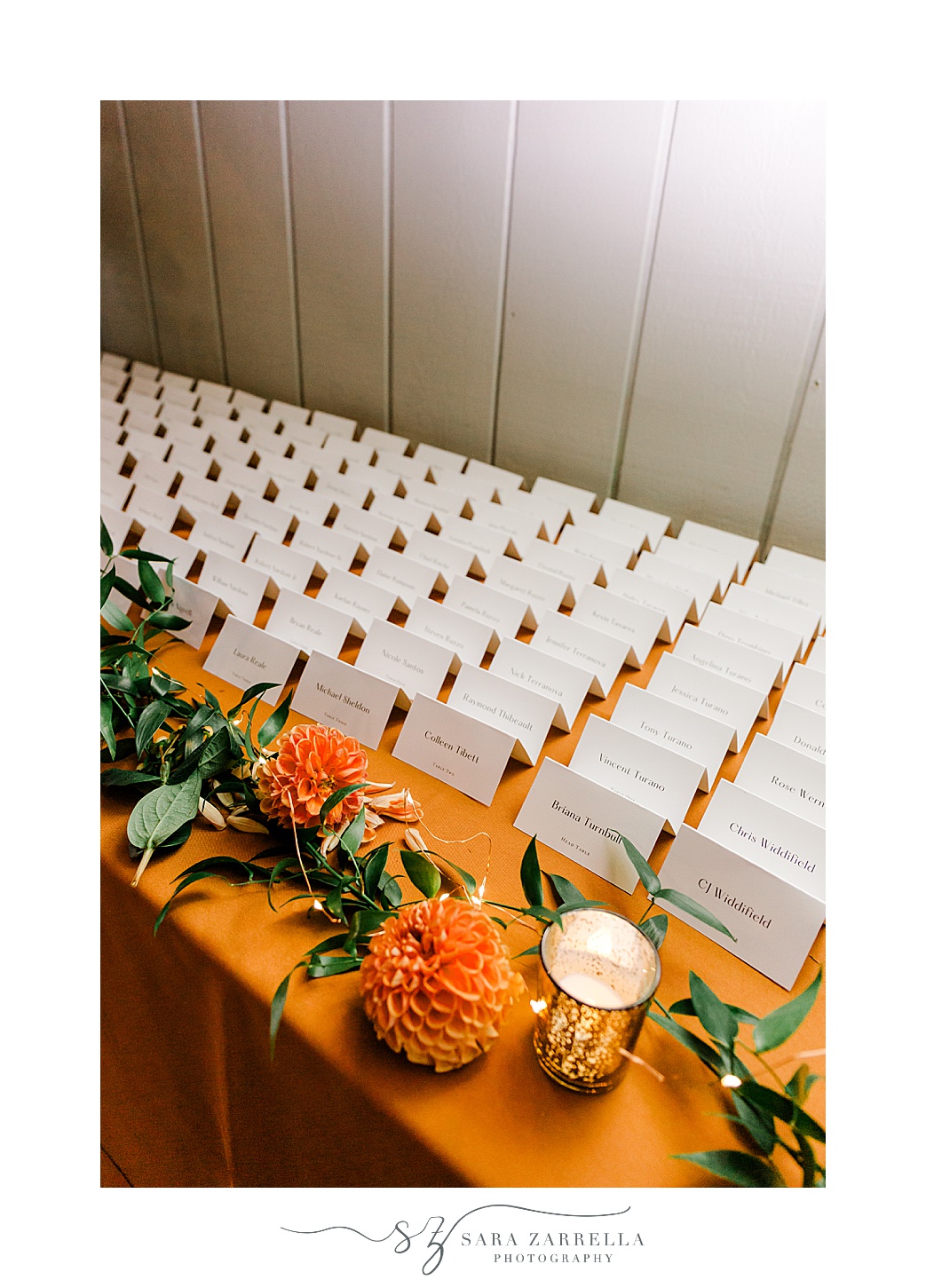 seating cards on table with orange flowers and greenery at the Windjammer