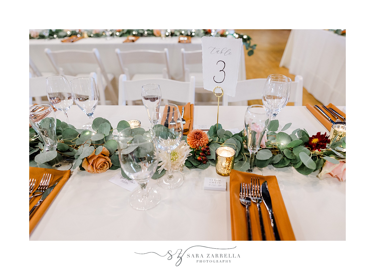 fall wedding reception at the Windjammer with orange accents and greenery down the center of the table 