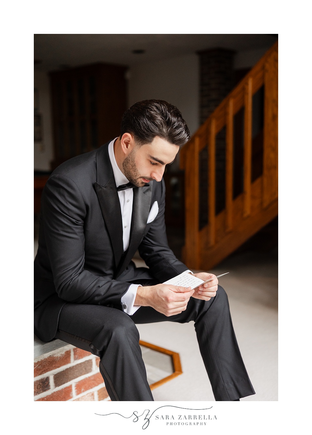 groom reads letter during wedding prep in Rhode Island