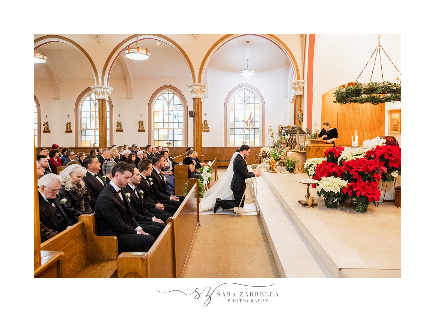 bride and groom kneel during wedding ceremony inside St. Thomas Church in Providence RI