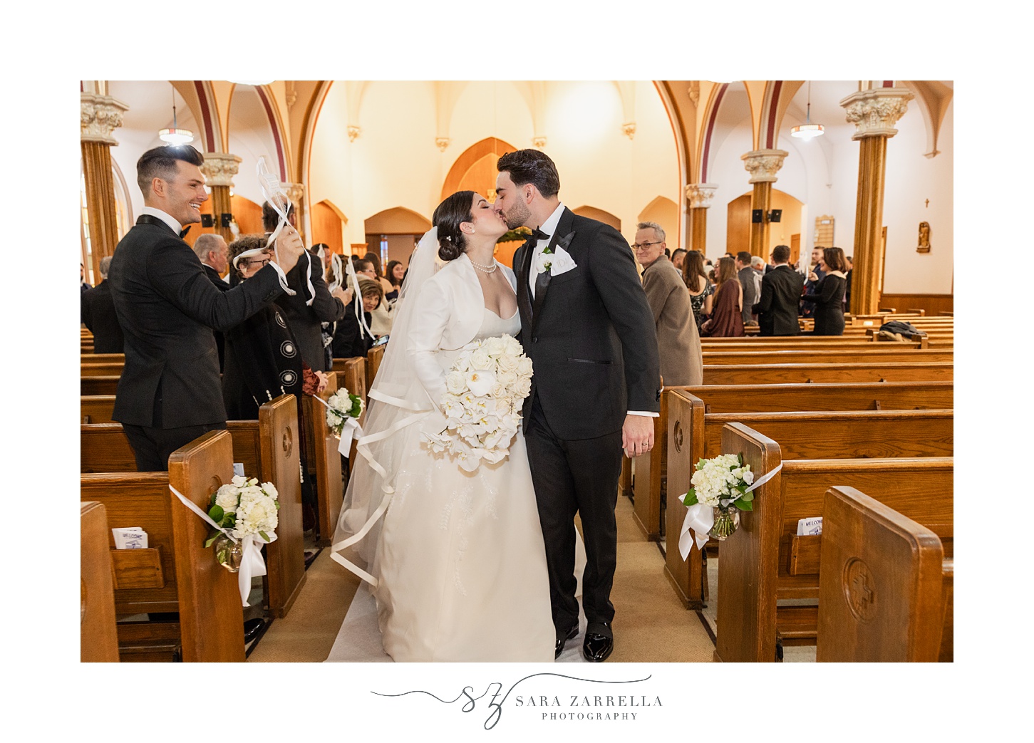 bride and groom kiss recessing up aisle after ceremony inside St. Thomas Church in Providence RI