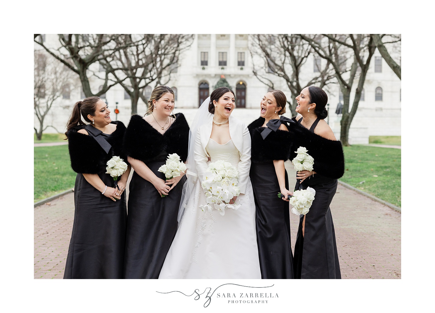 bride laughs with bridesmaids in black gowns outside RI State House