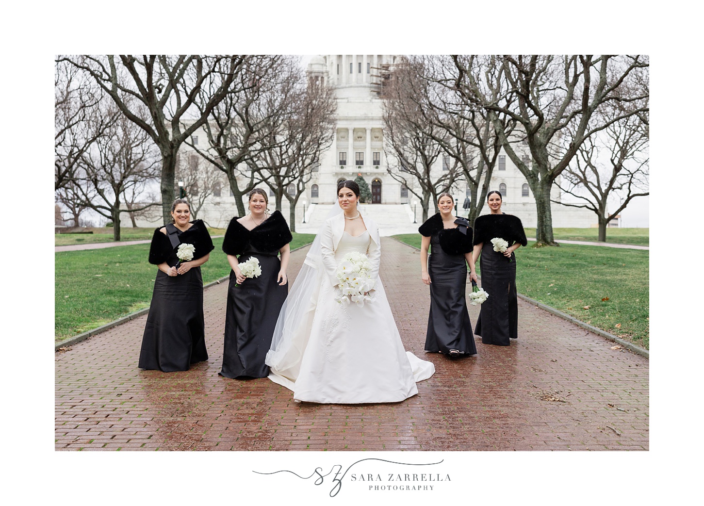 bride walks with bridesmaids in black gowns outside the RI State House