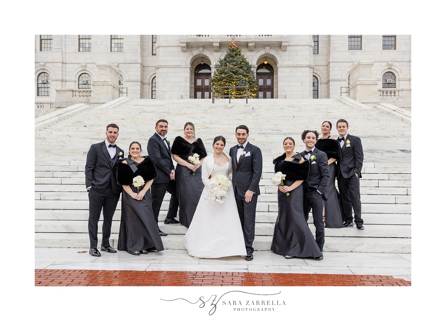 bride and groom stand on front steps of RI State House with wedding party 