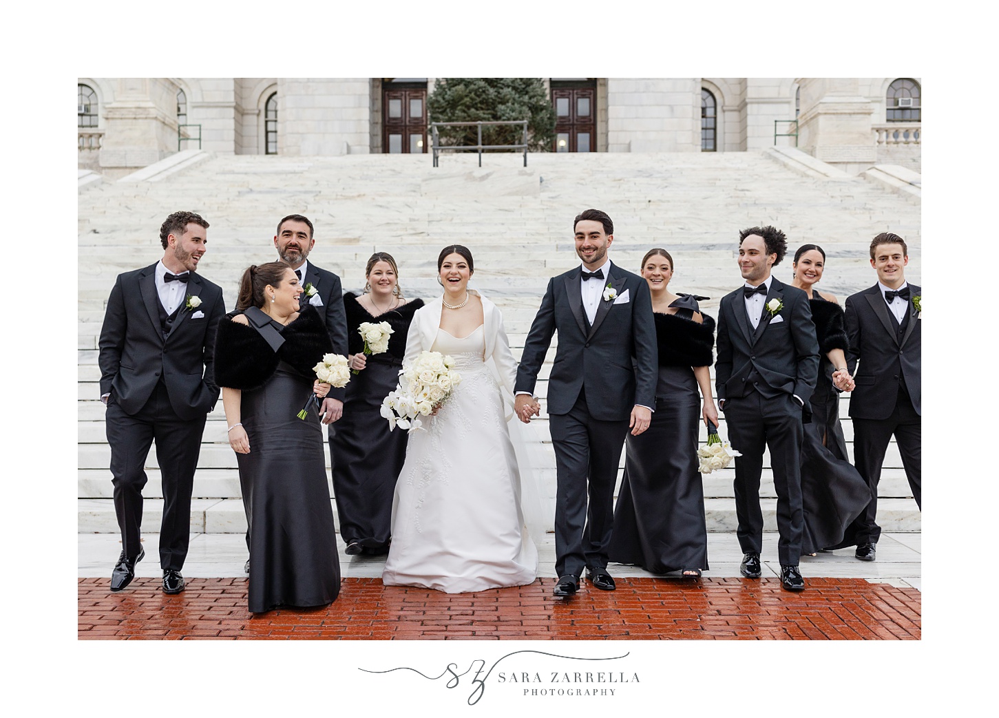 bride and groom hold hands walking down steps of the RI State House