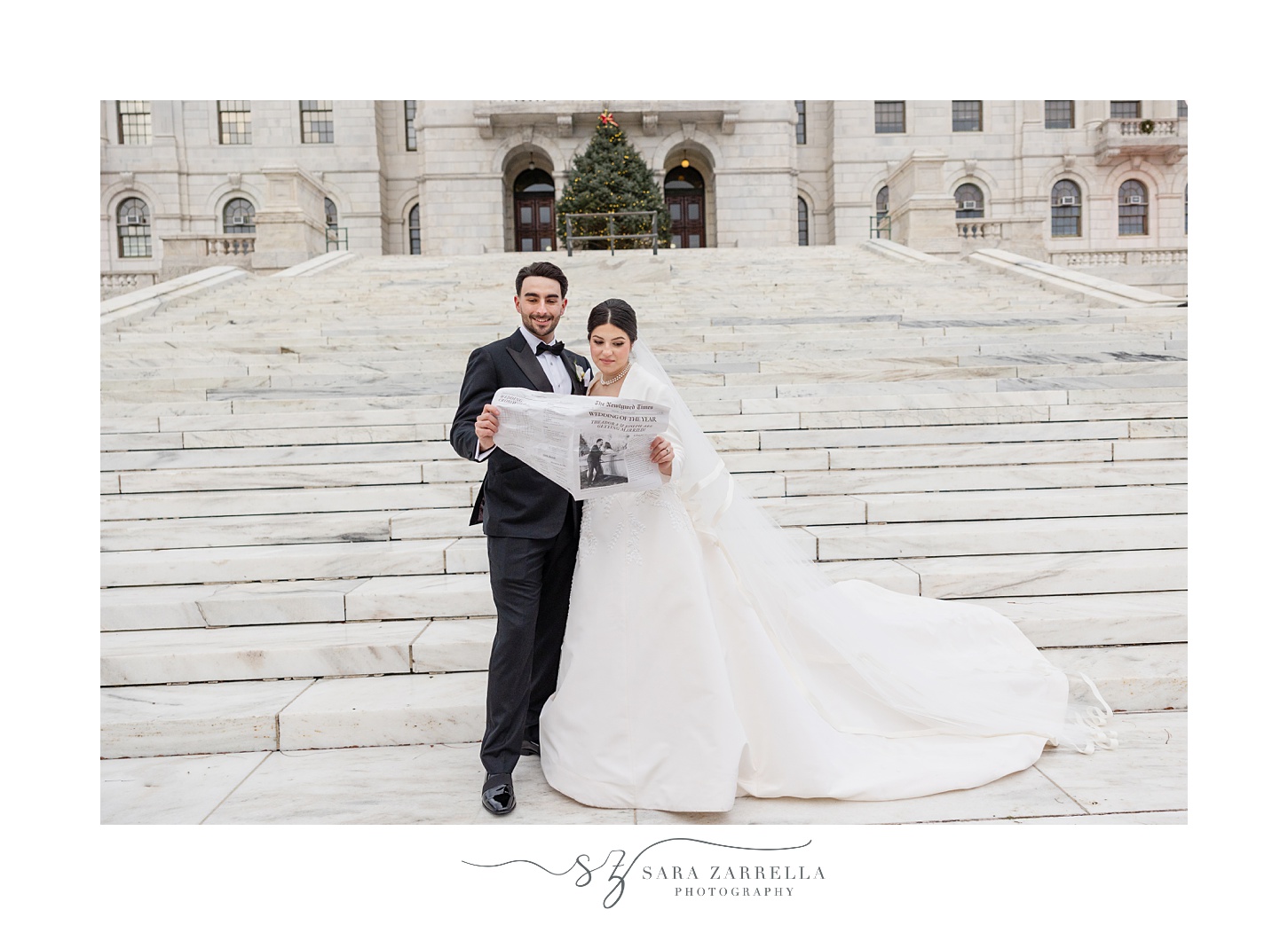 bride and groom stand on steps of the RI State House reading custom newspaper