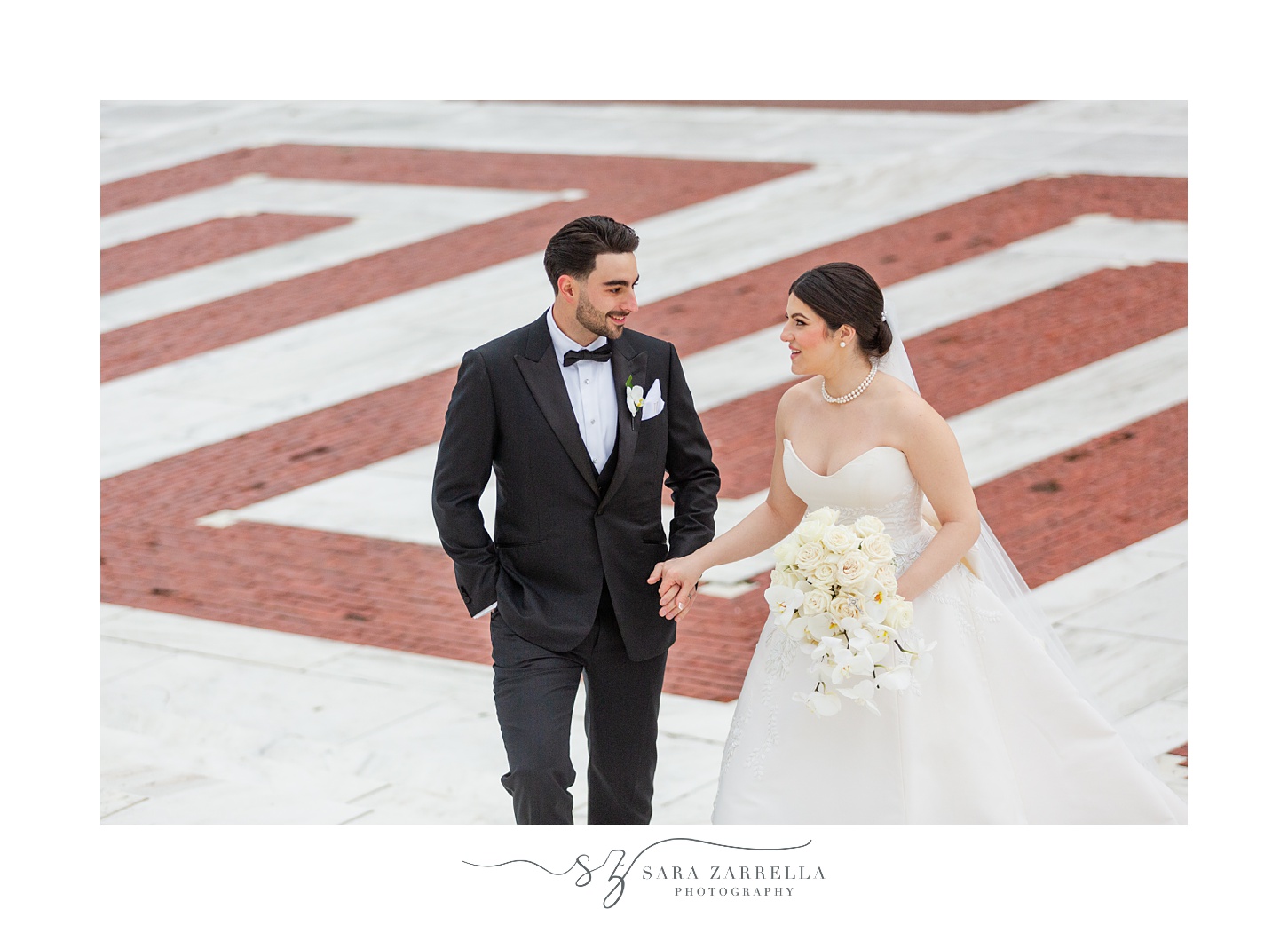 bride and groom talk and laugh walking up the steps of the RI State House