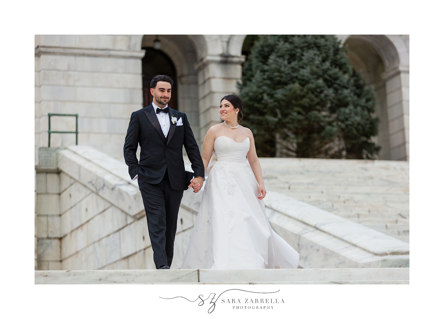 bride and groom hold hands walking on staircase outside the RI State House