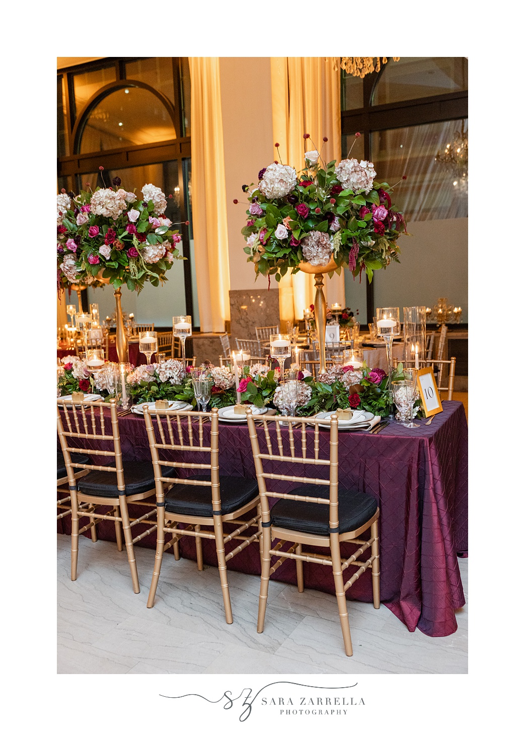 wedding reception tables with Burgundy clothes and tall floral centerpieces 