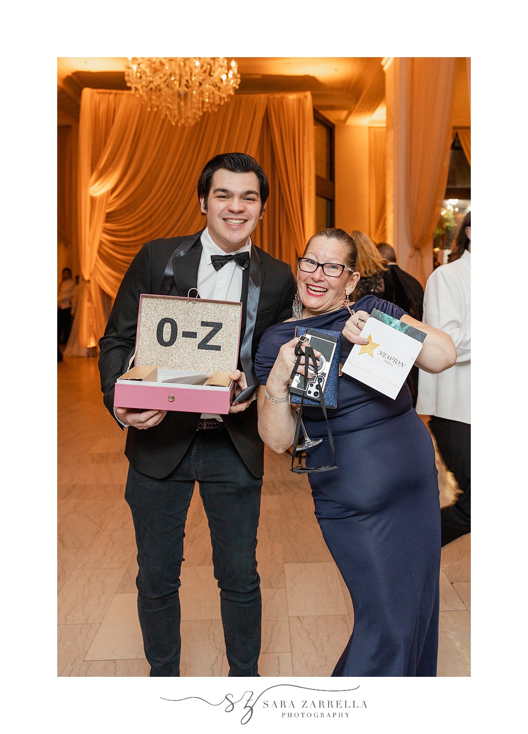 wedding guest holds up escort card by box 