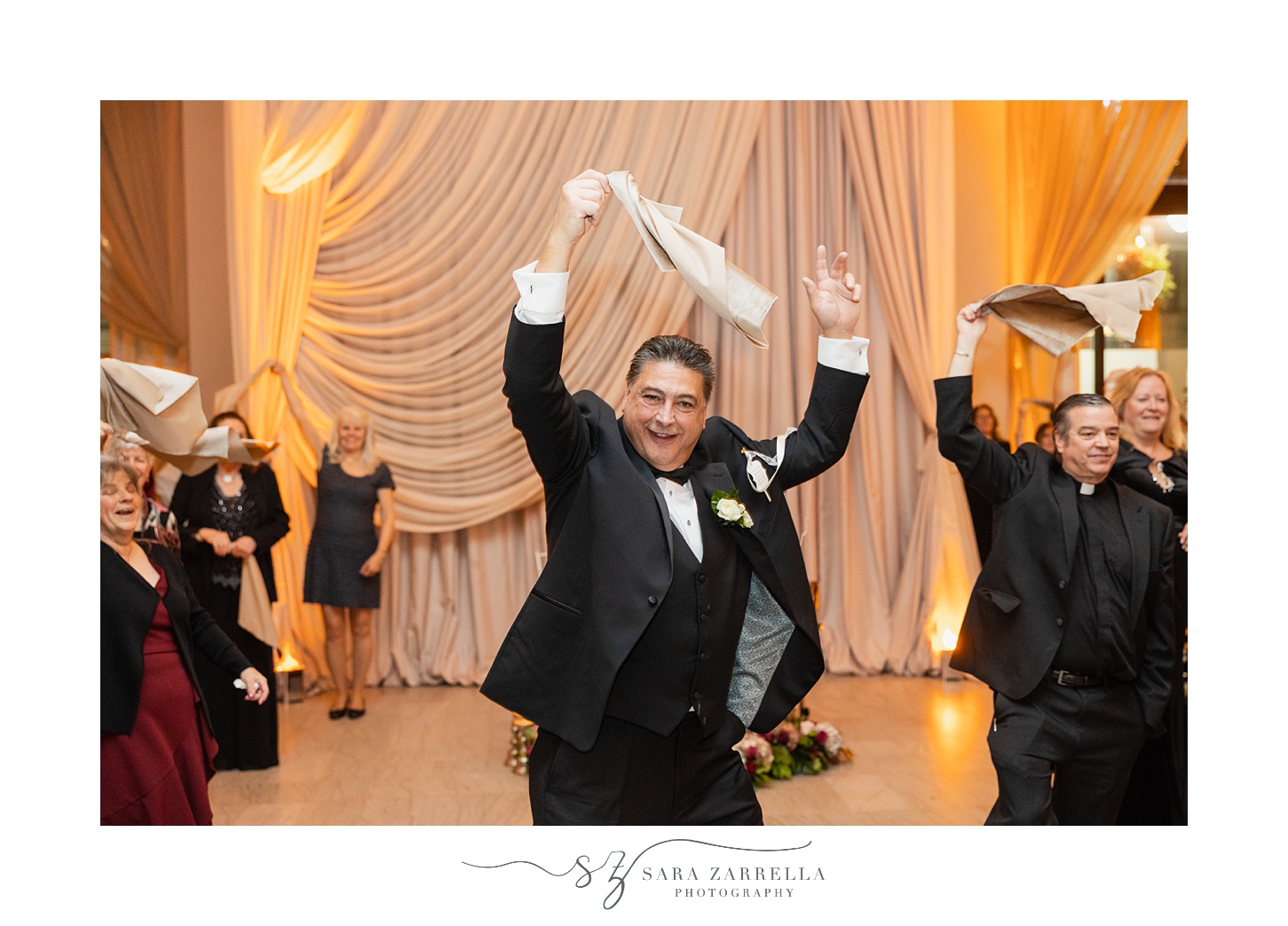 father twirls white napkins during RI wedding reception 