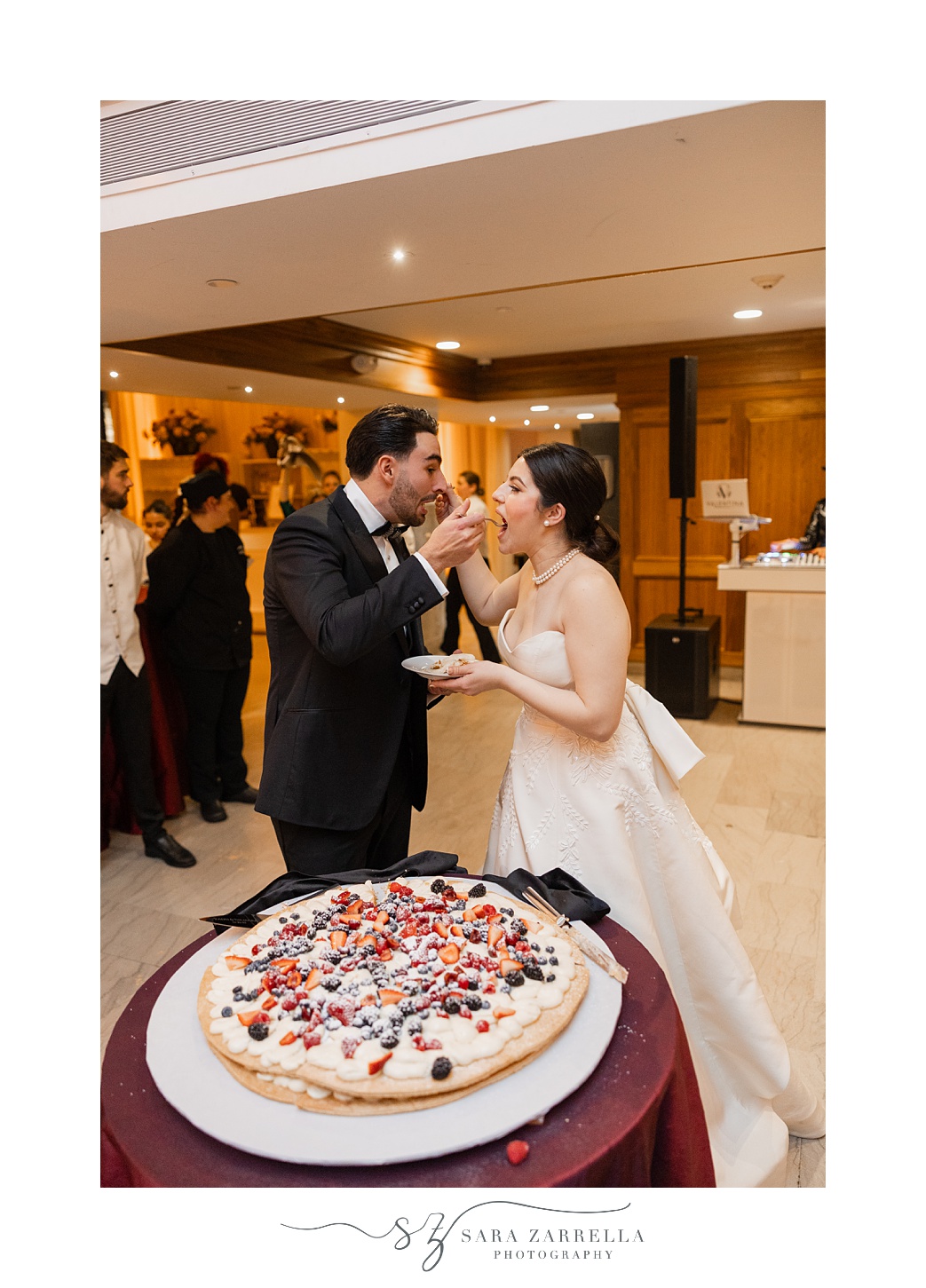 bride and groom feed each other wedding cake at the ballroom at the Providence G