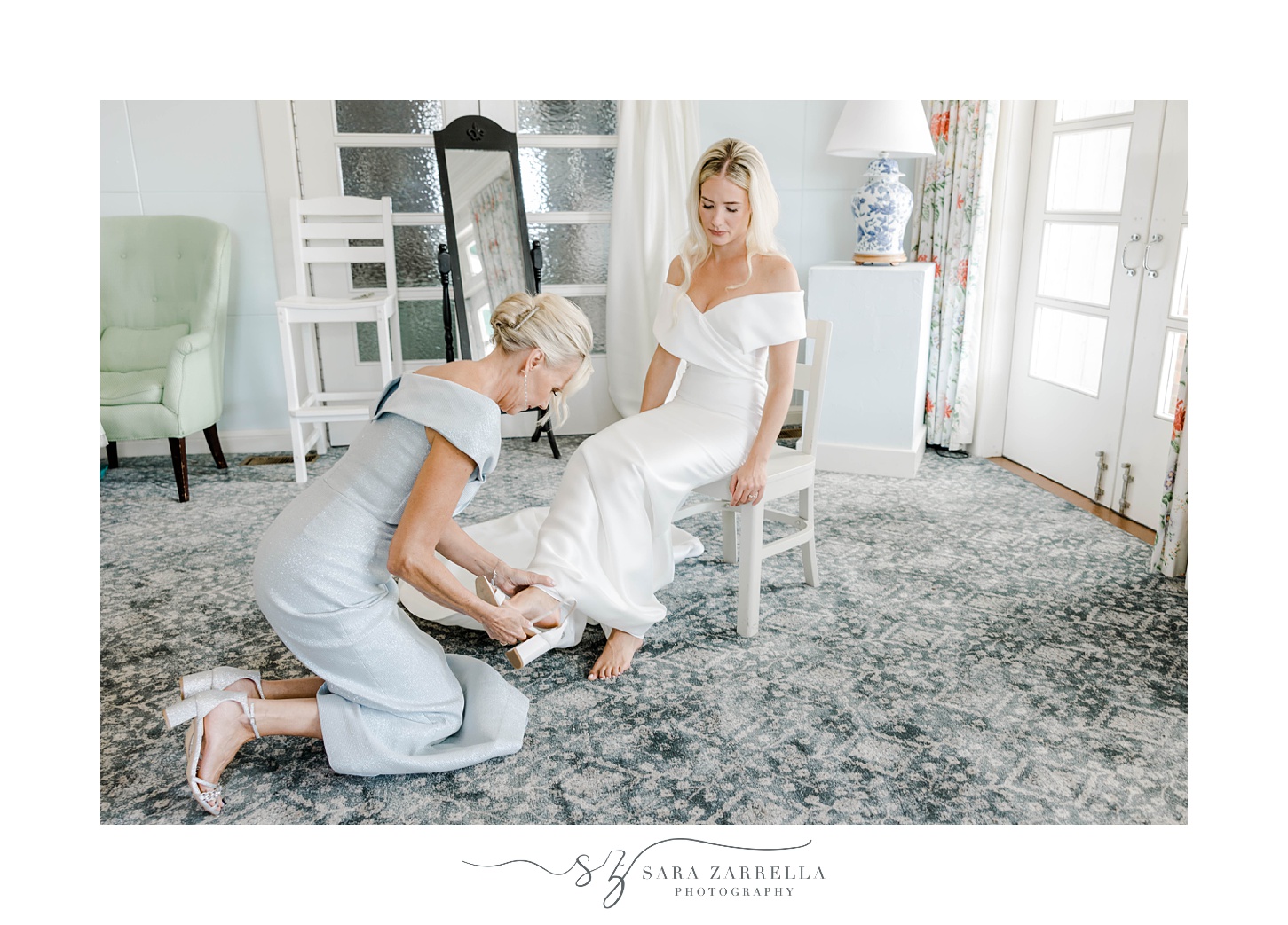 mother helps bride with shoes on wedding day in Rhode Island wedding day
