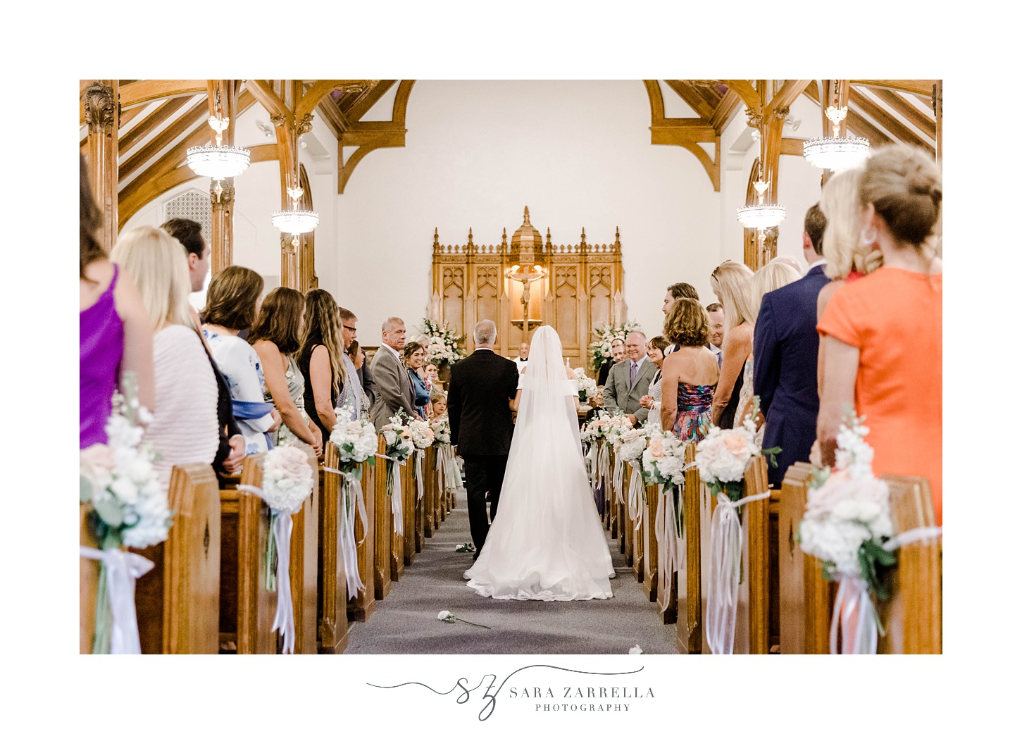 bride and father walk down aisle inside Saint Francis of Assisi Parish for wedding ceremony 