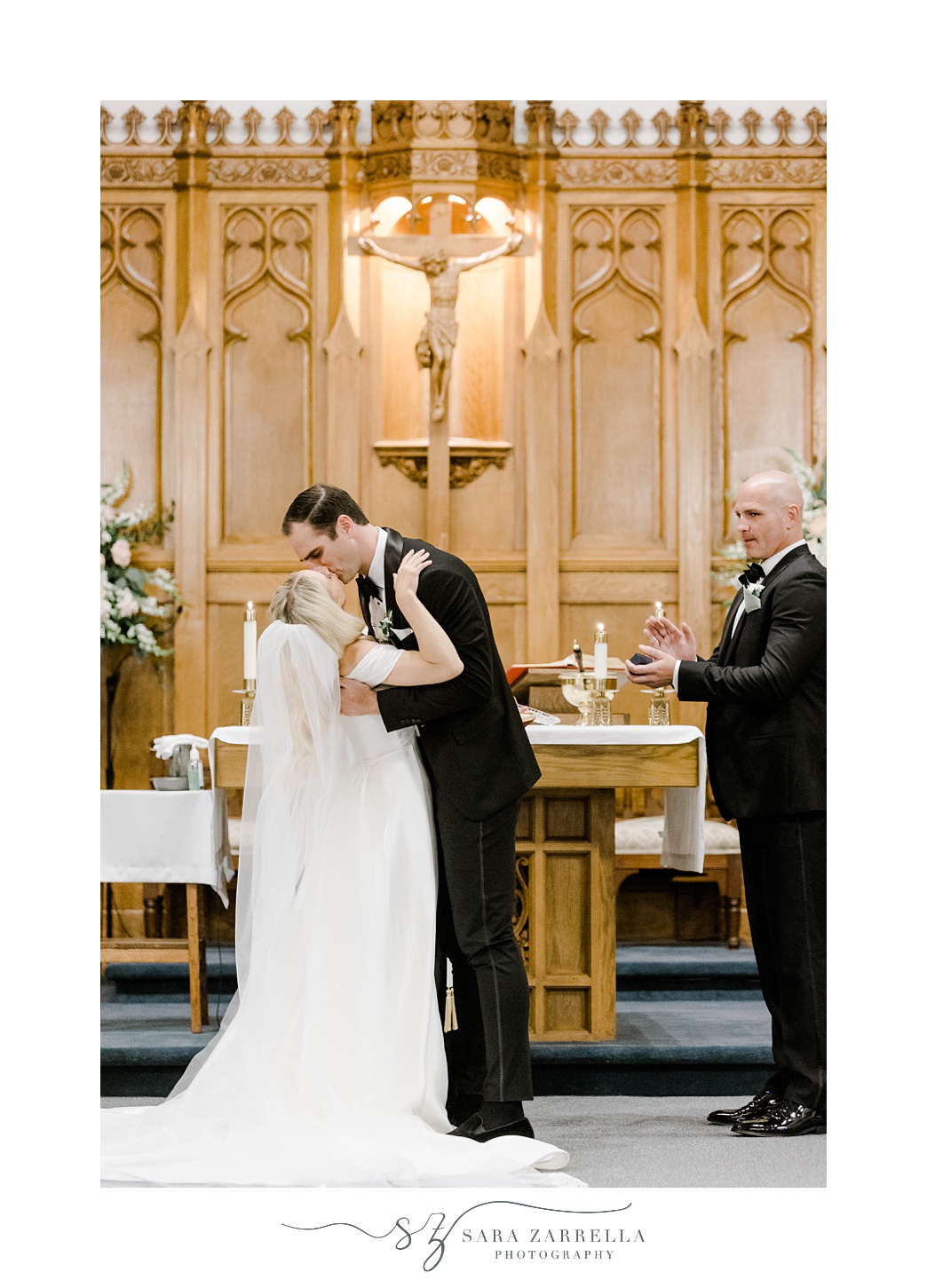 groom kisses bride dipping her during ceremony at Saint Francis of Assisi Parish