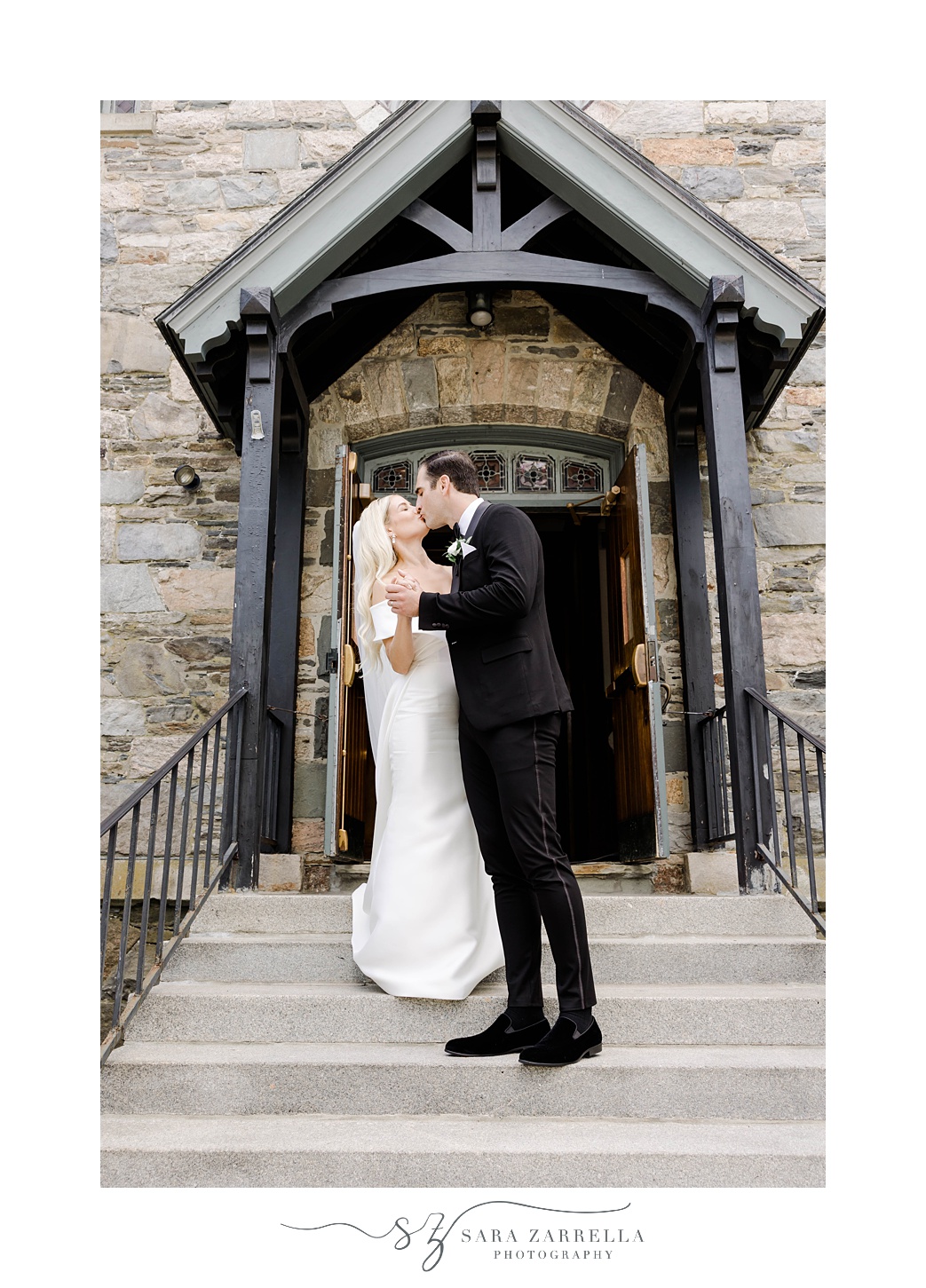 bride and groom stand on steps of Saint Francis of Assisi Parish