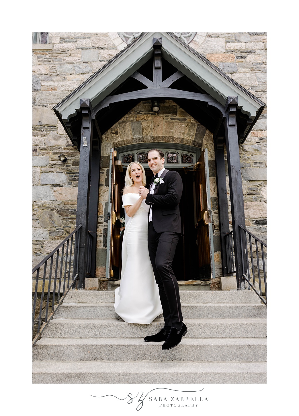 bride and groom laugh on steps of Saint Francis of Assisi Parish