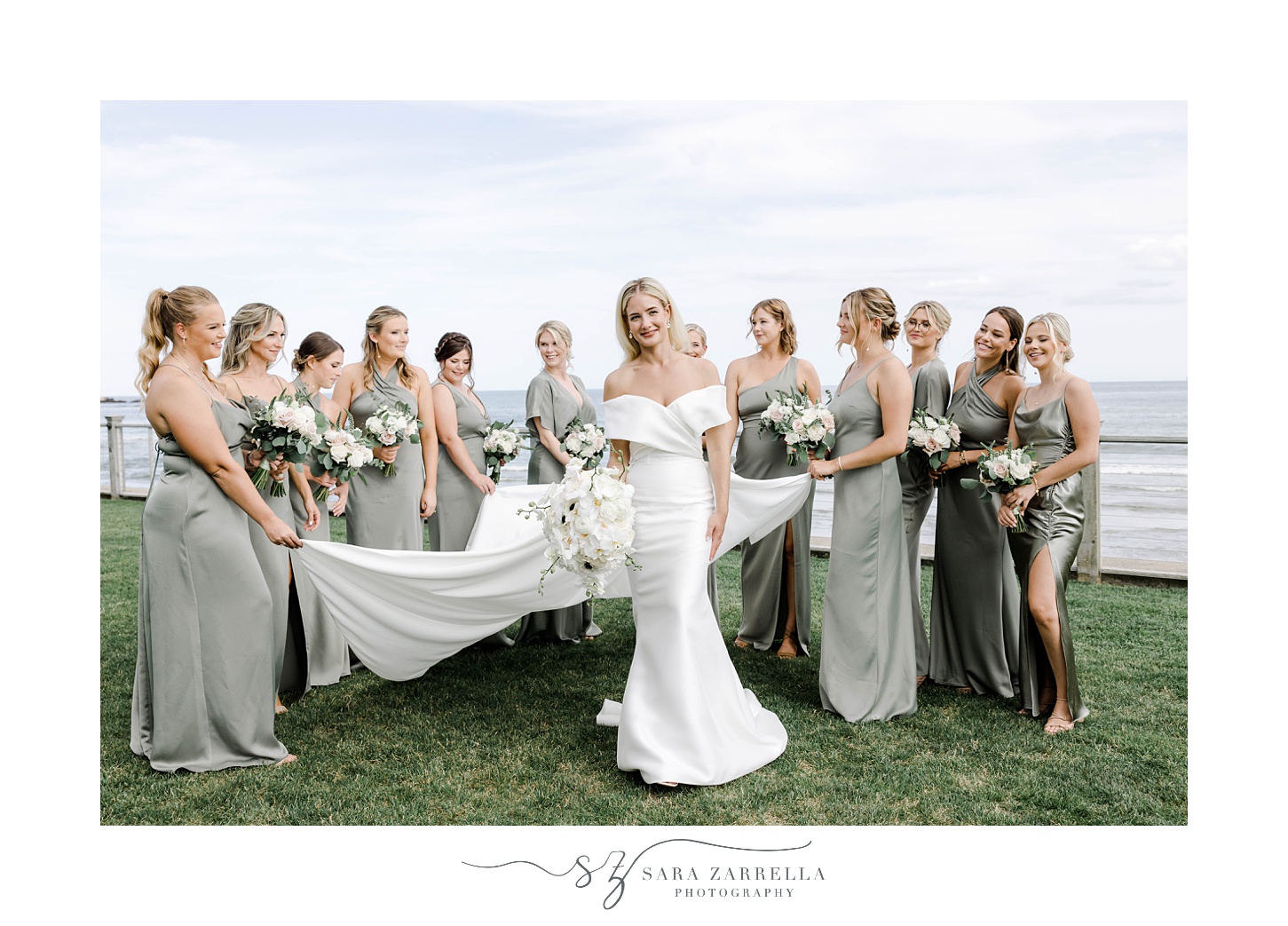 bridesmaids help bride with veil and skirt on hill at the Dunes Club