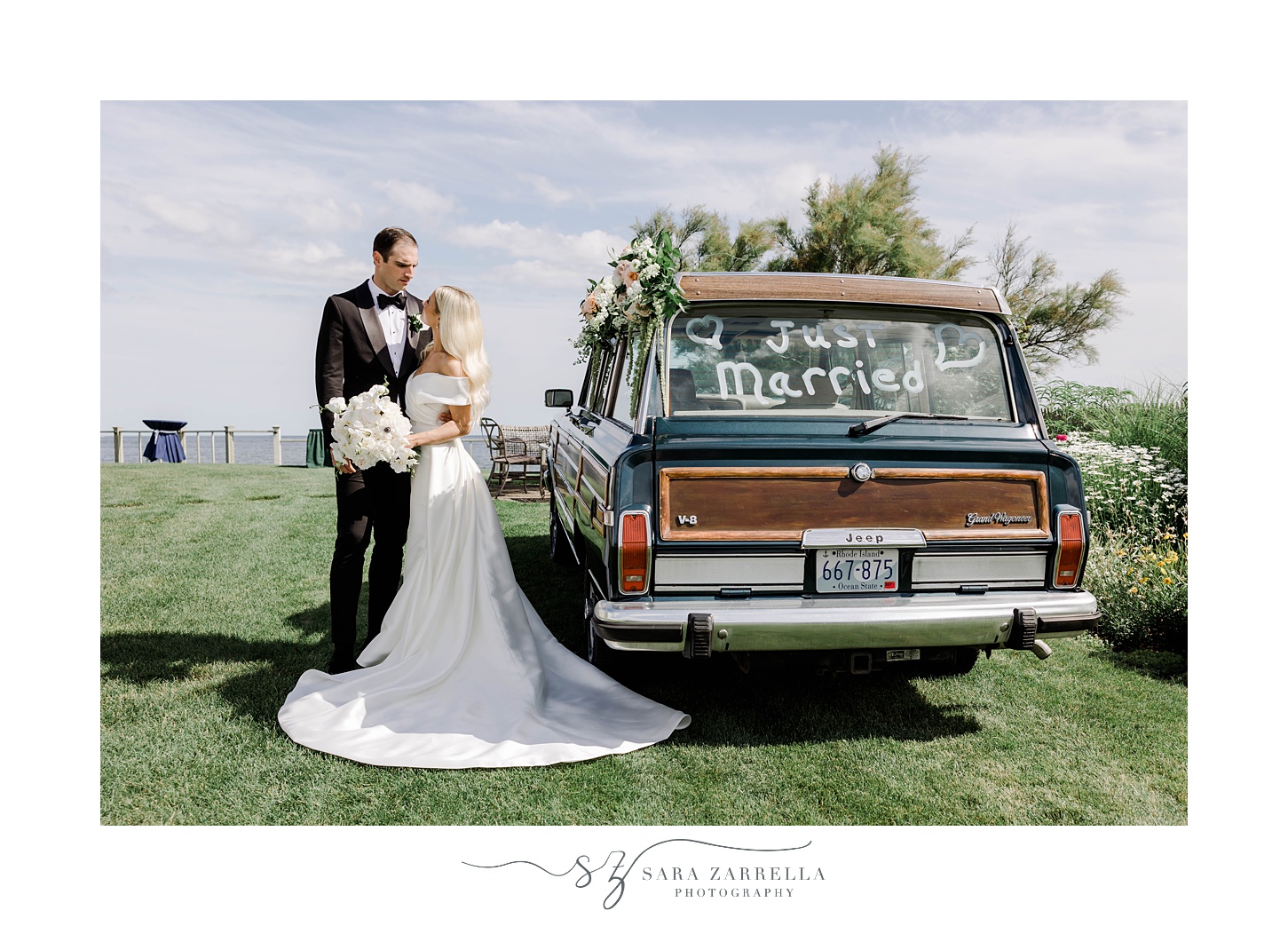 bride and groom stand next to Grand Jeep Wagoneer with white writing on the window