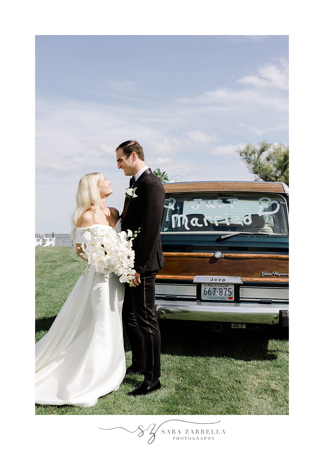 bride and groom lean against Grand Jeep Wagoneer with white writing on the window
