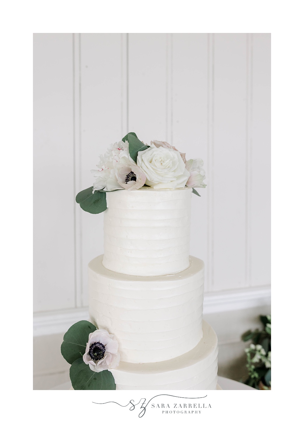 tiered wedding cake with white flowers at the Dunes Club