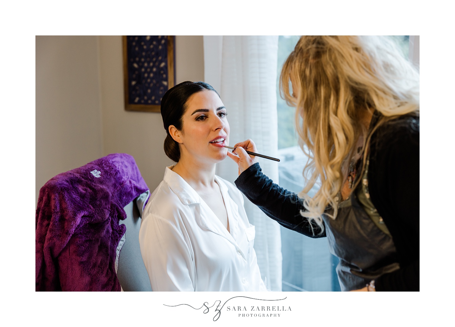 make up artist applies lip gloss for bride 