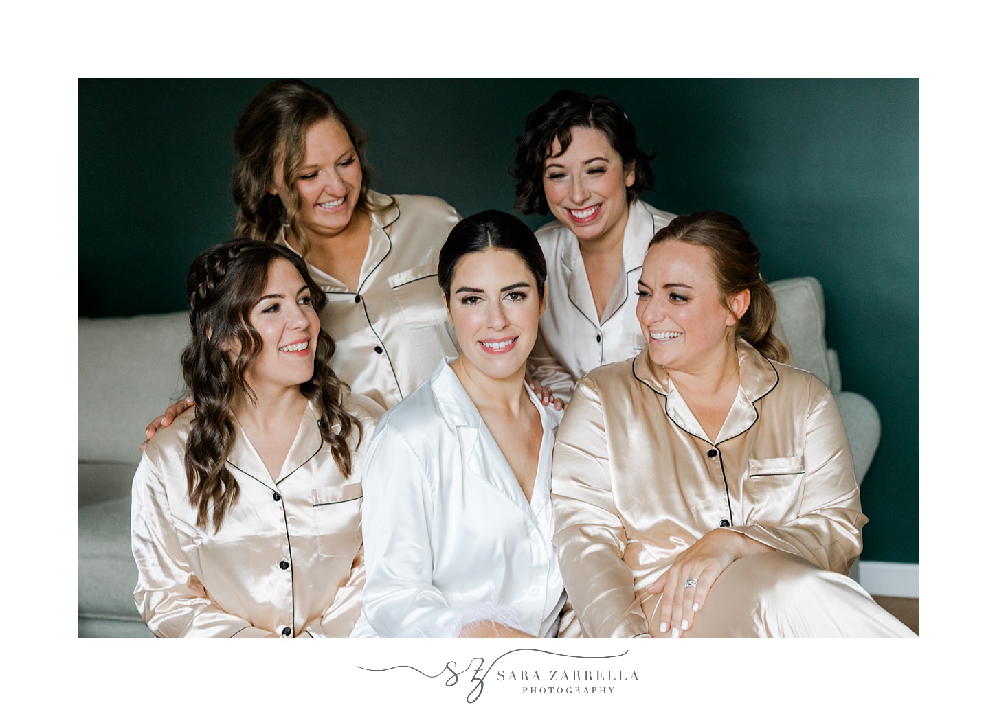 bride sits with bridesmaids in satin robes 