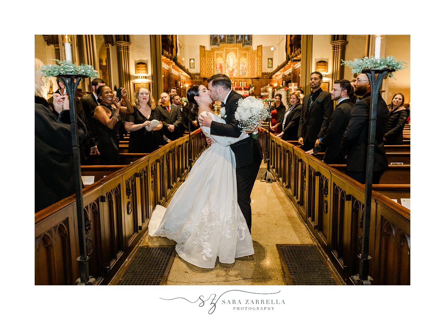 bride and groom kiss in aisle following traditional church wedding in Providence RI