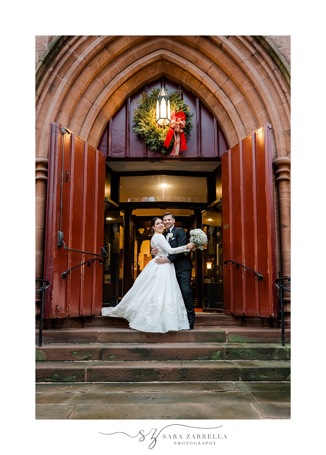 bride and groom hug outside Providence RI church with red doors 