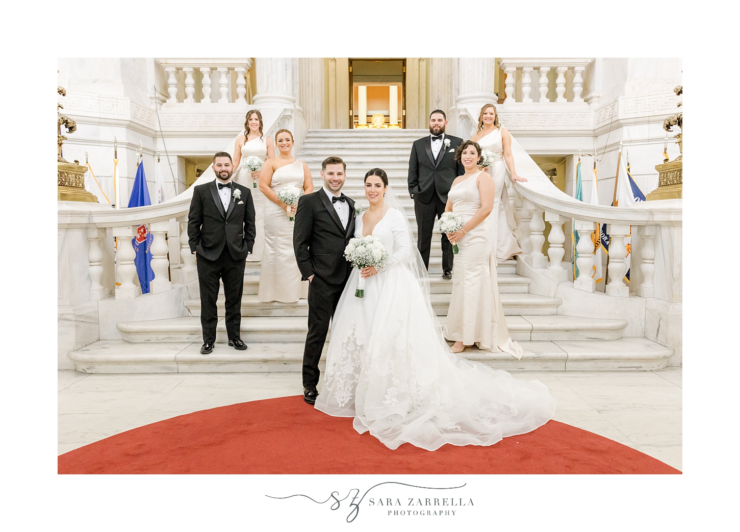 newlyweds stand on steps inside the Rhode Island State House in Providence RI with bridal party