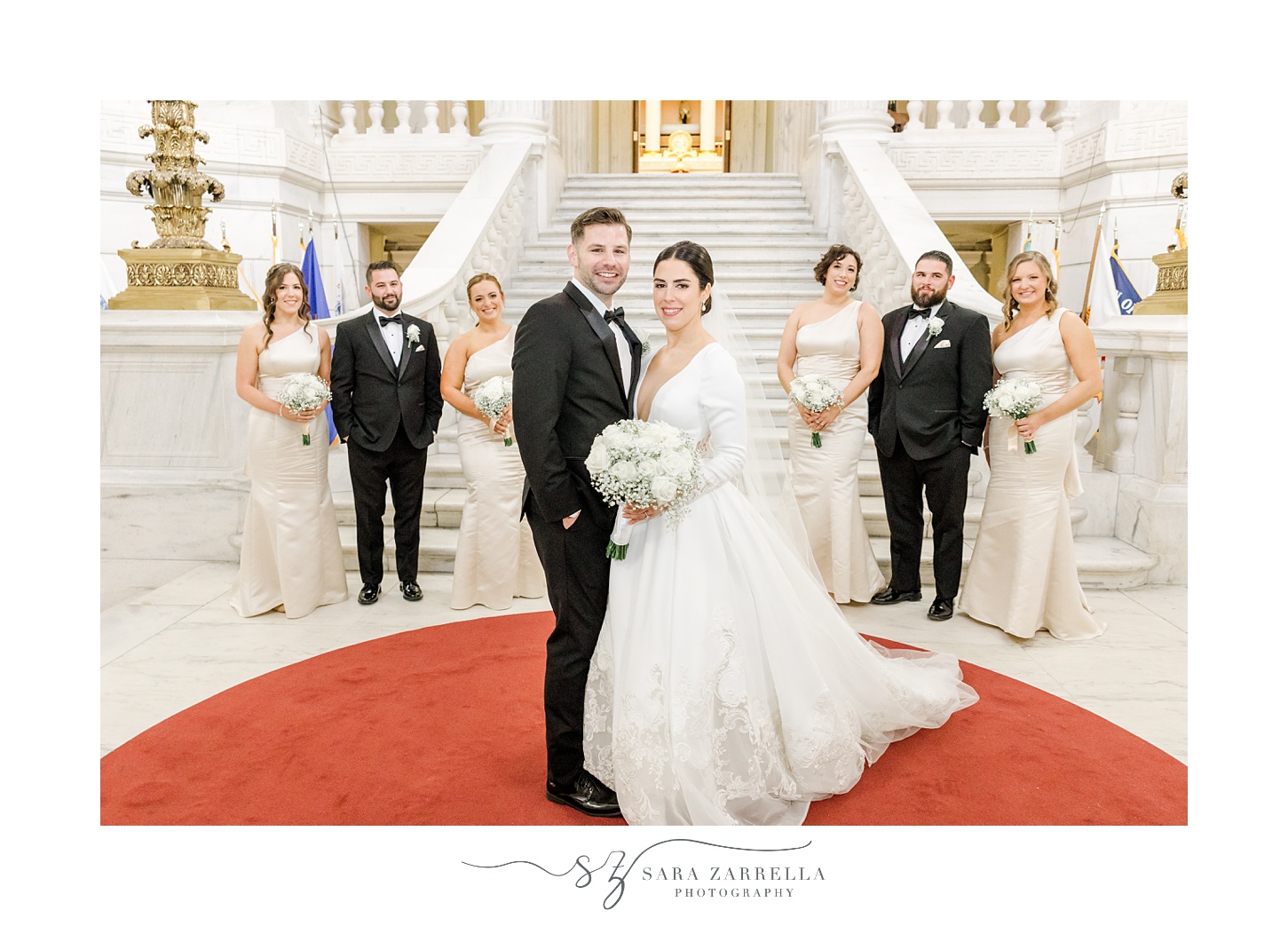 bride and groom hug in front of wedding party in ivory gowns and black tuxes