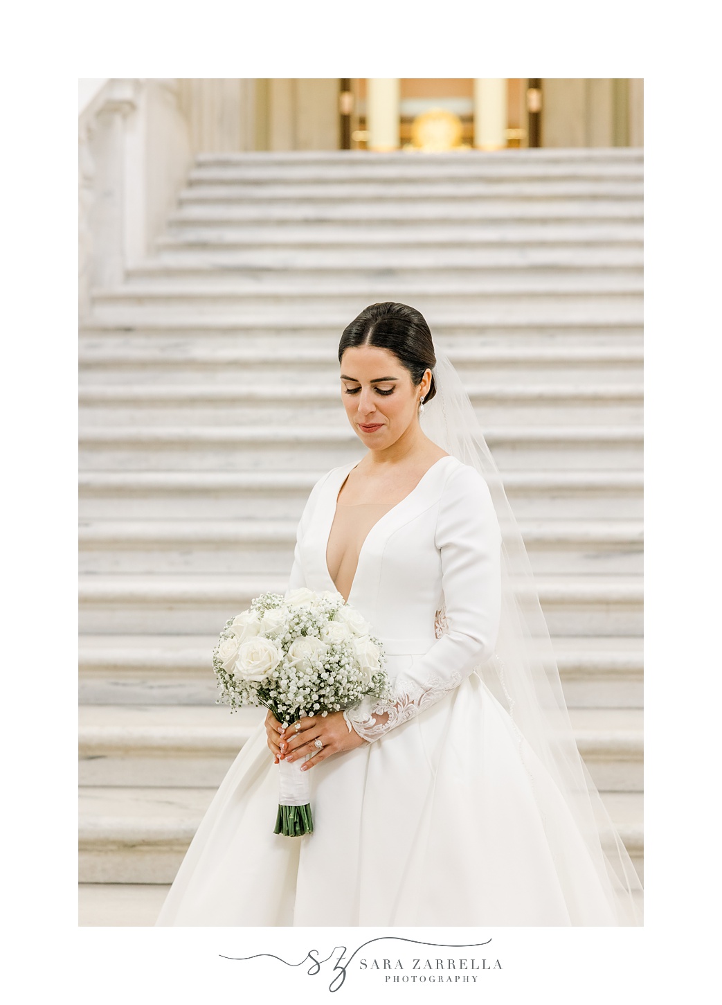 bride holds bouquet of white roses and baby's breath on steps at the Rhode Island State House in Providence RI