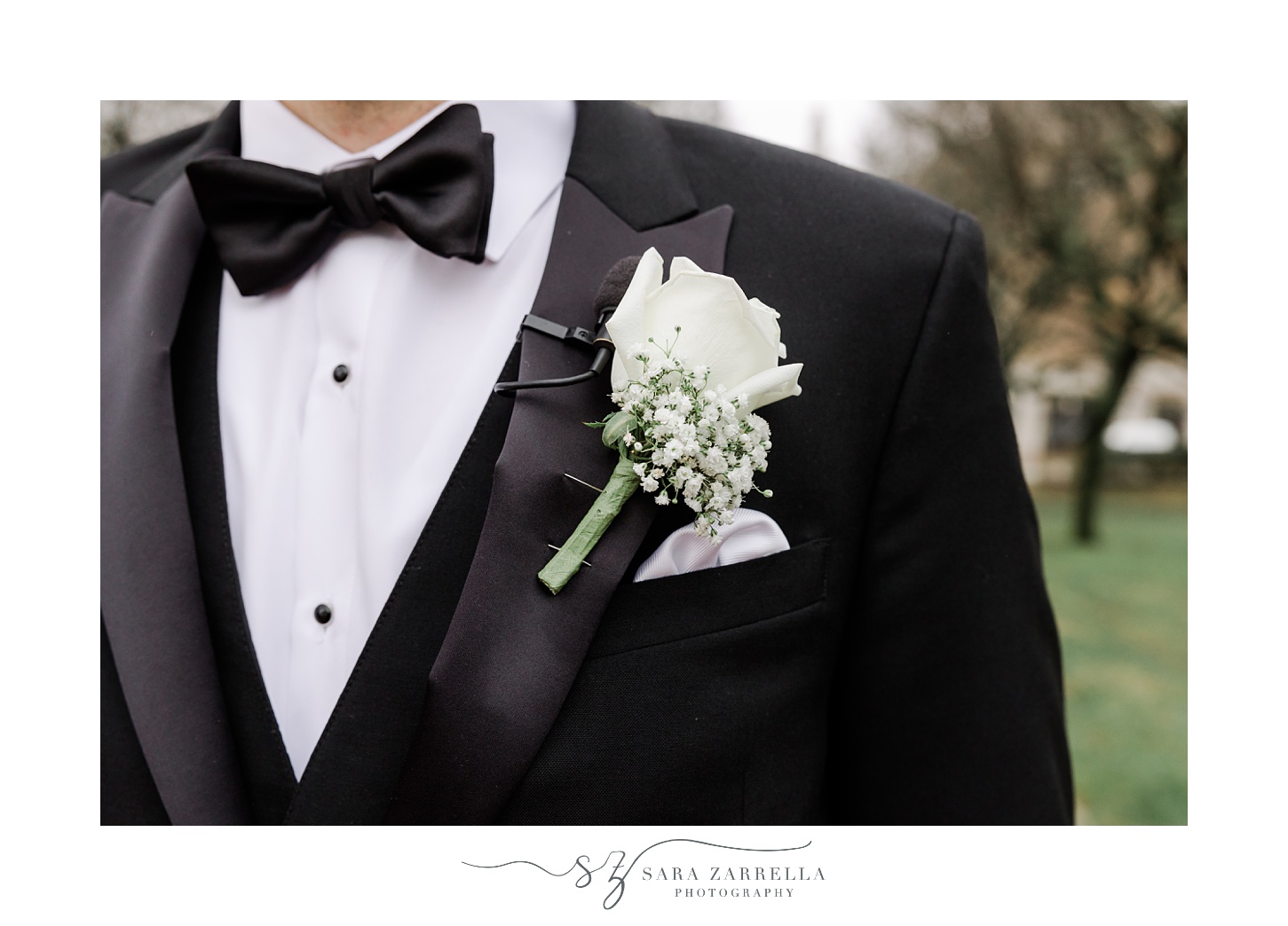 groom's boutonnière of white rose with baby's breath 