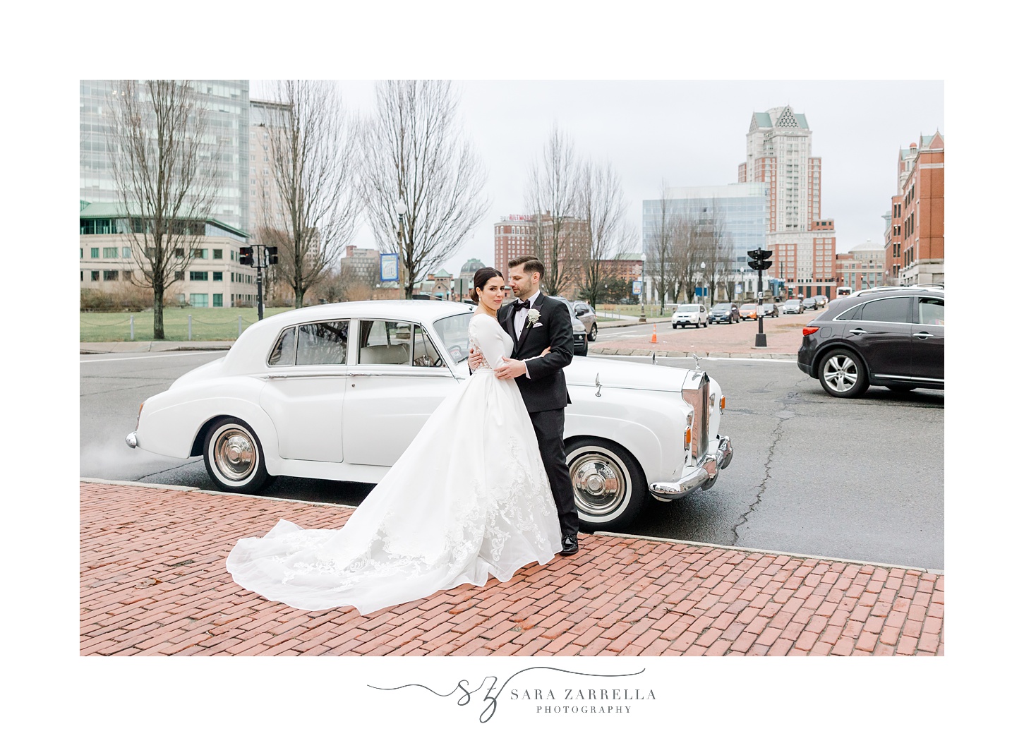 newlyweds hug near white classic car in Rhode Island