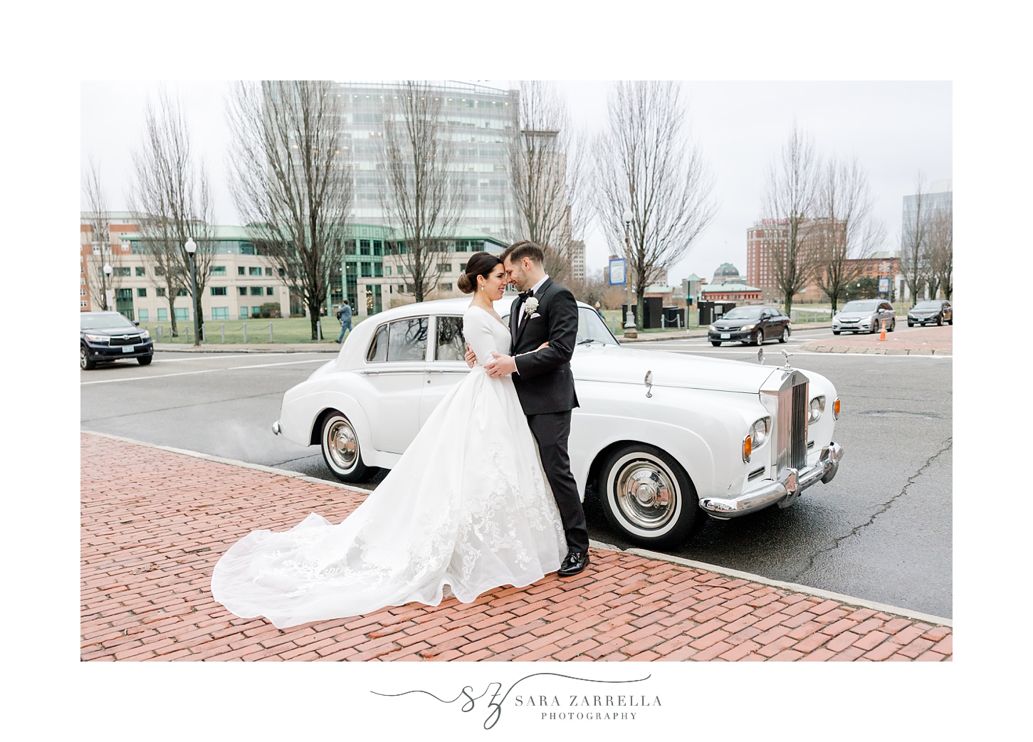 newlyweds hug near white classic car in Providence RI