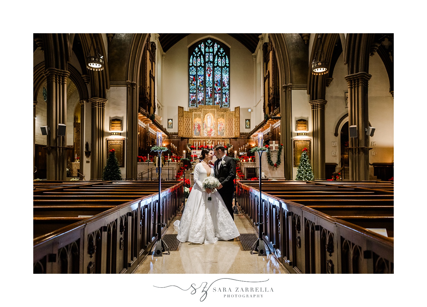 bride and groom stand between pews inside Providence RI church