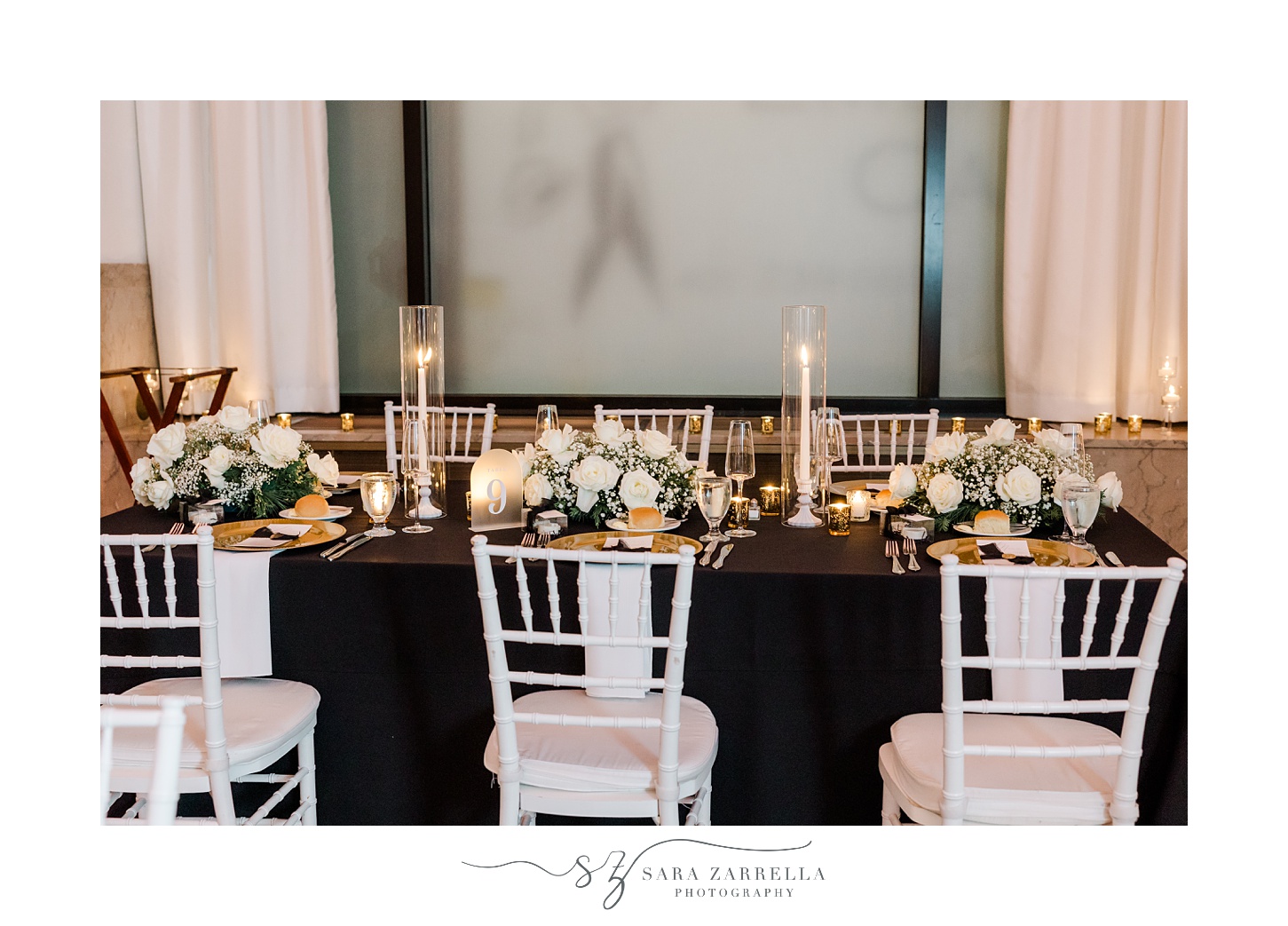 reception with taper candles, gold plates, and black napkins 